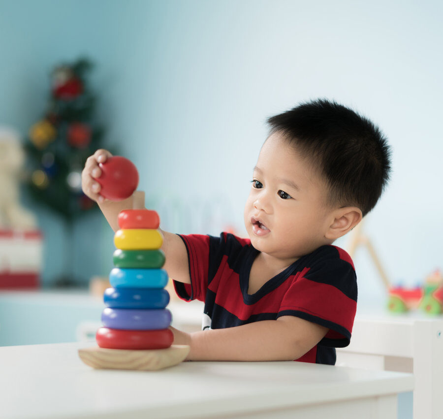 A toddler stacking colorful rings