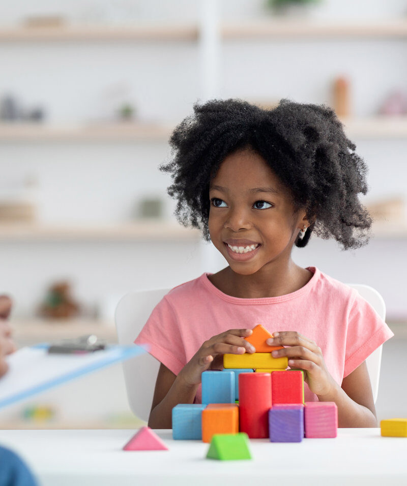 A young girl concentrating as she builds with blocks